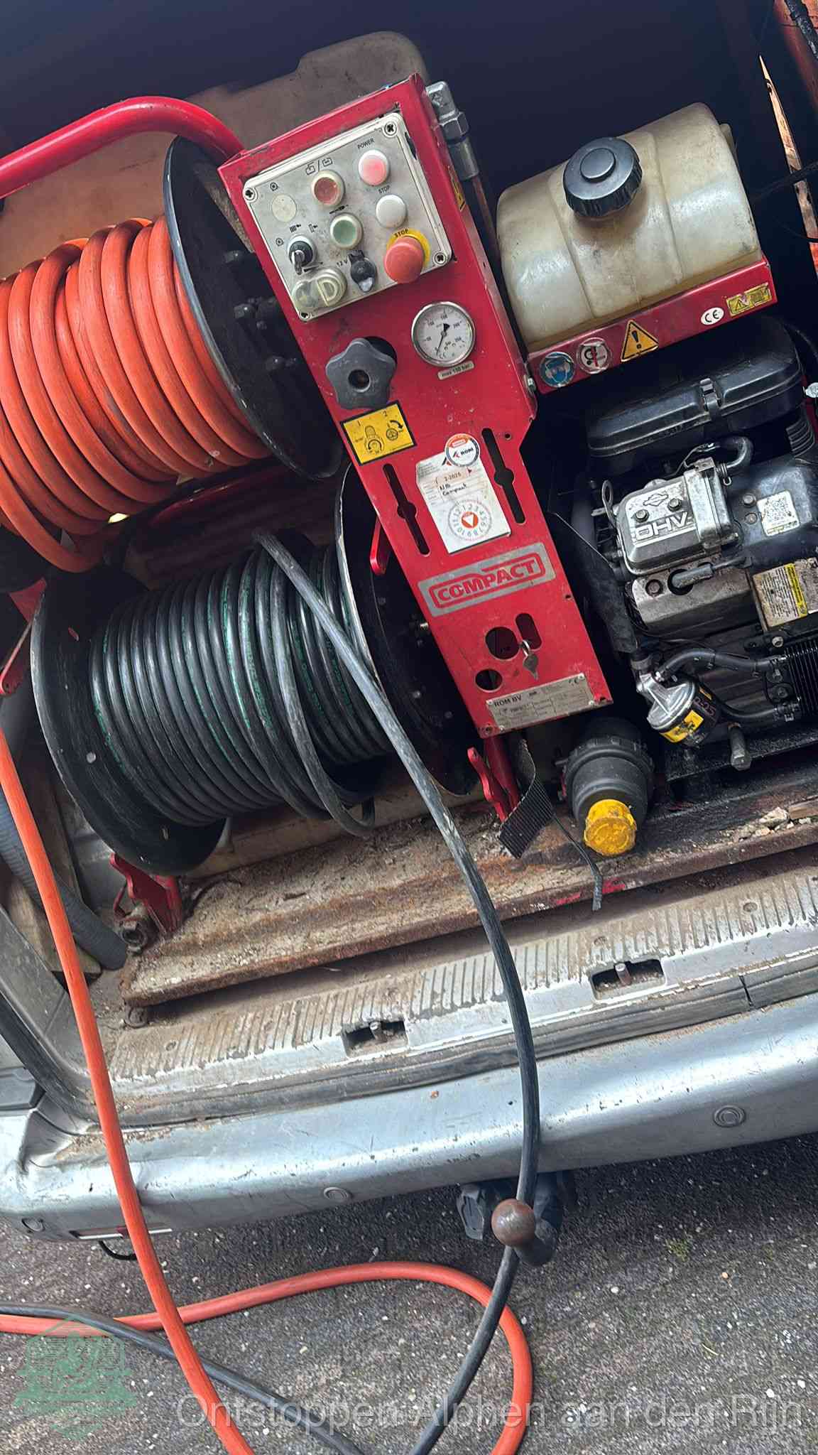 Een rood hogedruk-rioolreinigingstoestel in de laadbak van de bedrijfsbus, apparatuur voor een hardnekkige afvoerverstopping in Alphen aan den Rijn