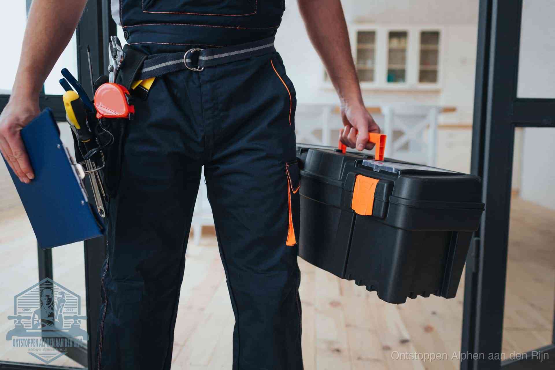 Een monteur met gereedschapsriem en klembord in een keuken, klaar om een transparante prijs voor het gootsteen ontstoppen in Alphen aan den Rijn te geven