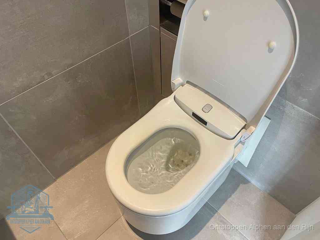 Een toiletpot vol troebel water met drijvend papier en restanten, de meest voorkomende oorzaak van een verstopte wc in Alphen aan den Rijn