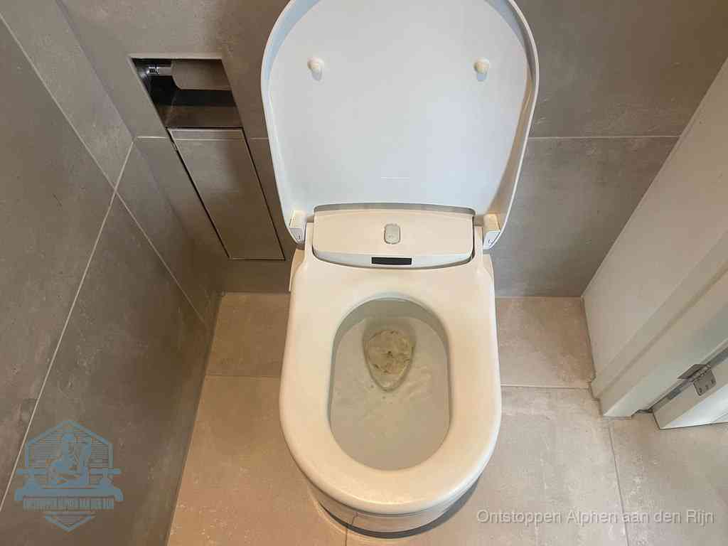 Een wit hangtoilet waarin een prop wc-papier op het water blijft drijven, een duidelijk signaal van een verstopte wc in Alphen aan den Rijn