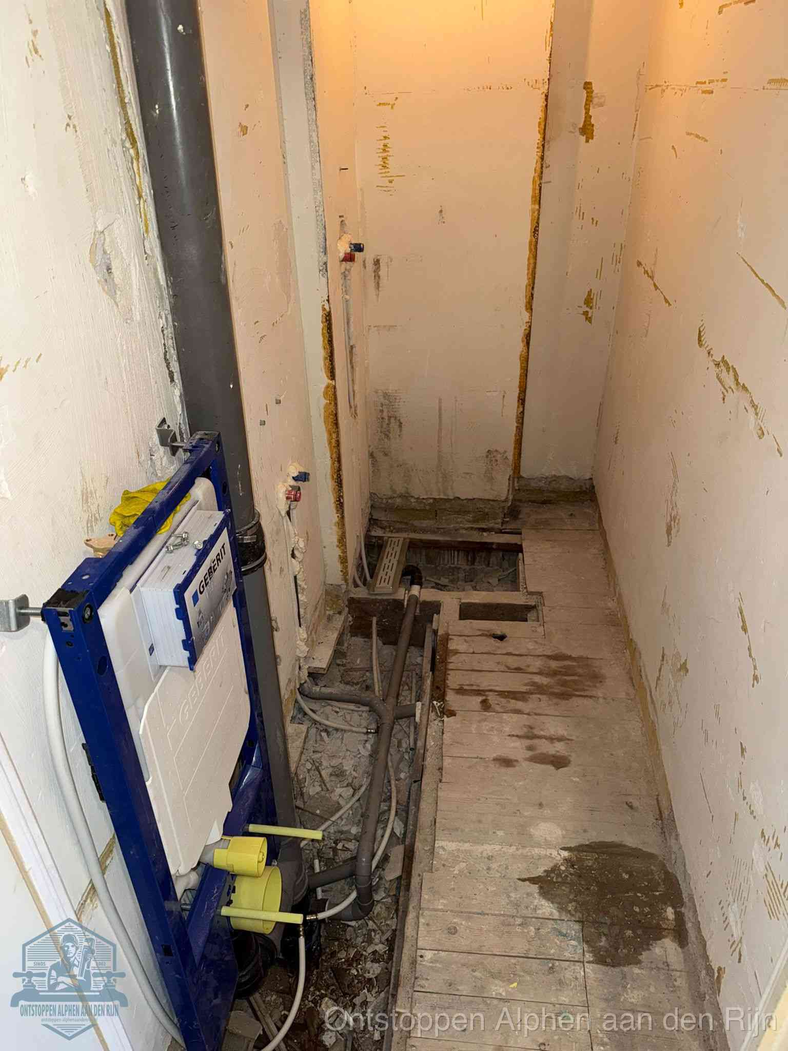 Een opgebroken toiletruimte tijdens renovatie met een Geberit inbouwreservoir en blootliggende oude afvoerleidingen, typisch voor oudere woningen in Alphen aan den Rijn